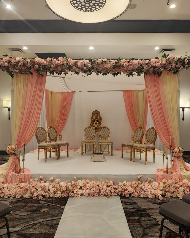 Mandap with a peach and gold floral canopy over a white aisle