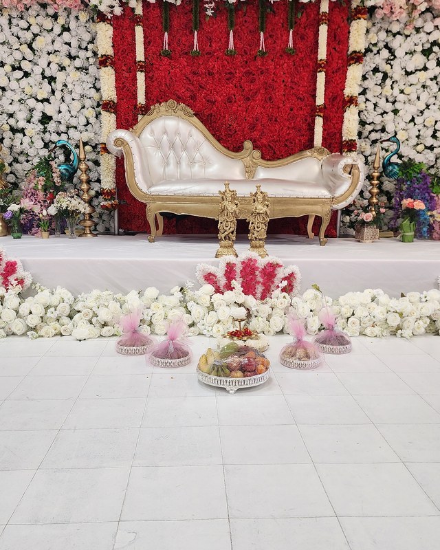 Red and white floral wall with a gold settee and petal detailing